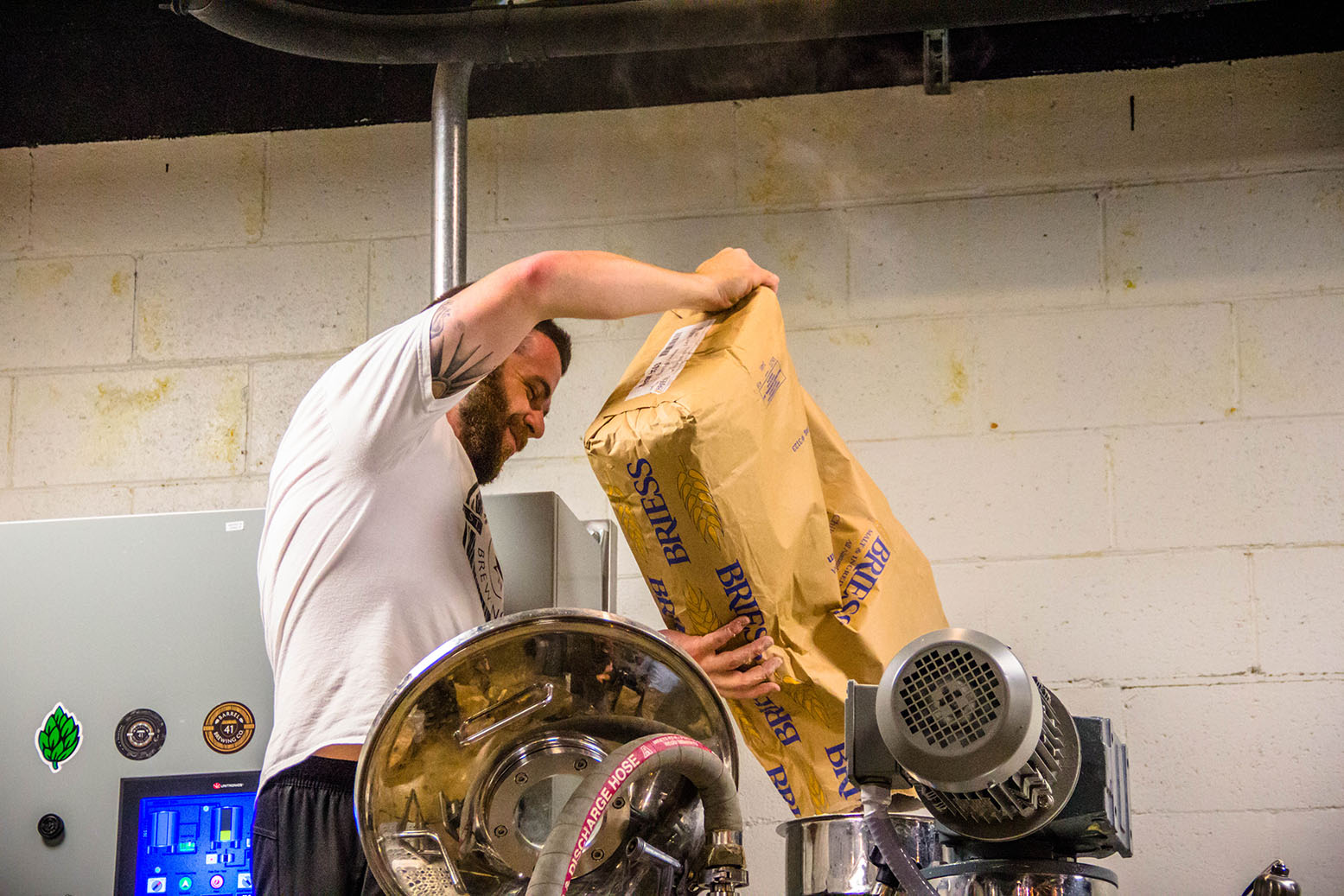 Nathan Sharpless pouring barley into a brewing drum